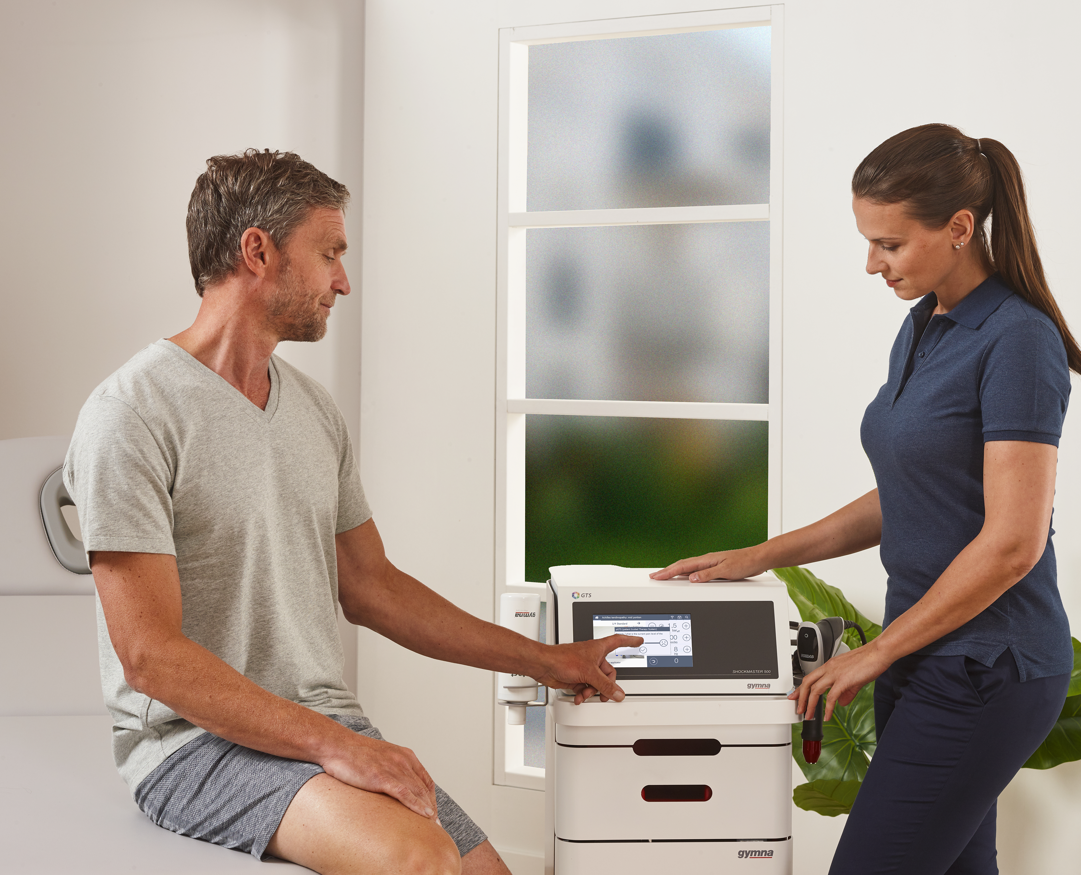 Physiotherapist explaining the shockwave therapy treatment to patient